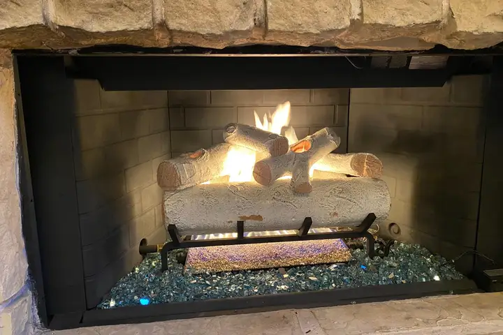 Gas log set installed and burning in a Dallas fireplace